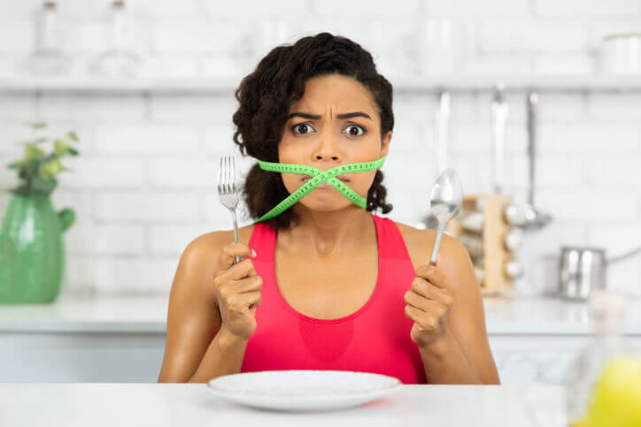 woman with green measuring tape around her mouth